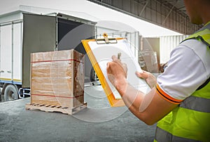 Worker Holds a Clipboard Controlling the Loading of Cargo into Shipping containers. Packaging Boxes Goods. Loading Dock. Logistics