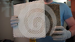 Worker HVAC services changing a folded dirty air filter in the HVAC furnace system in home. Close up