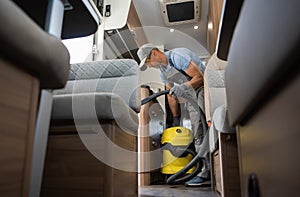 Worker with Industrial Grade Vacuum Cleaner Cleaning Motorhome Camper Van Interior