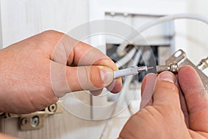 Worker inserts connector of a TV antenna coaxial cable.