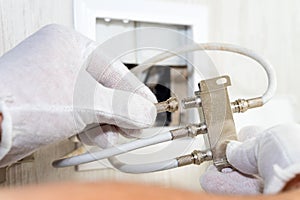 Worker inserts connector of a TV antenna coaxial cable to a splitter. photo