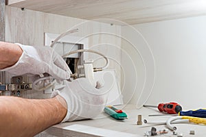 Worker inserts connector of a TV antenna coaxial cable to a splitter.