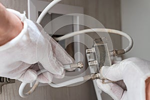 Worker inserts connector of a TV antenna coaxial cable to a splitter.