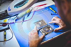 Worker fixing HDD disc in workshop