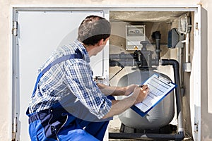 Worker Inspecting Water Pump And Pipes