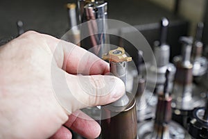 A worker inspects tools for working on a CNC milling machine