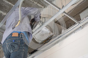 Worker install air ventilation duct pipes on ceiling