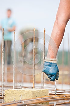 Worker installing binding wires in formwork