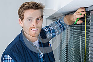 Worker installing blind on window