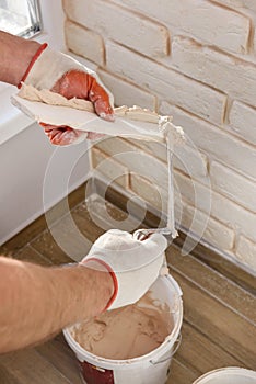 A worker is installing brick tiles on the wall