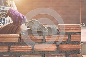 Worker installing bricks wall in process of house building