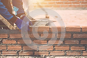 Worker installing bricks wall in process of house building