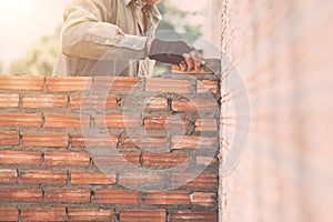 Worker installing bricks wall in process of house building