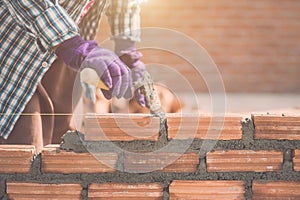 Worker installing bricks wall in process of house building