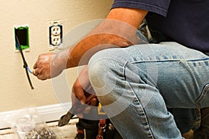 Worker installing cable inside wall