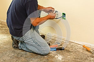 Worker installing cable inside wall