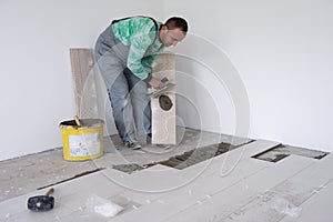 Worker installing the ceramic wood effect tiles on the floor