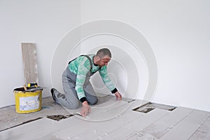 Worker installing the ceramic wood effect tiles on the floor