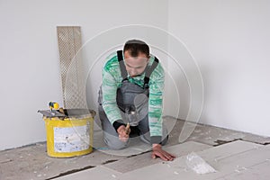 Worker installing the ceramic wood effect tiles on the floor