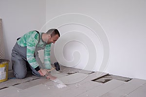 Worker installing the ceramic wood effect tiles on the floor