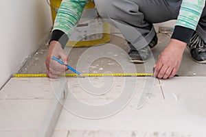 Worker installing the ceramic wood effect tiles on the floor