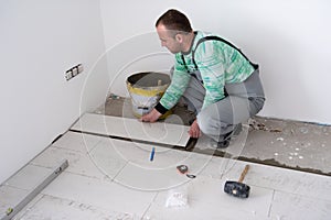 Worker installing the ceramic wood effect tiles on the floor