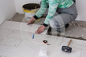 Worker installing the ceramic wood effect tiles on the floor