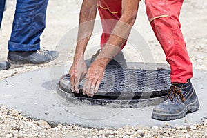 Worker installing cover at manhole