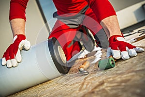 Worker Installing EPDM vinyl on top of BUilding Roof