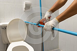 Worker installing floating pipeline on the wall in the old bathroom