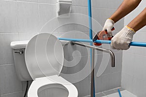 Worker installing floating pipeline on the wall in the old bathroom