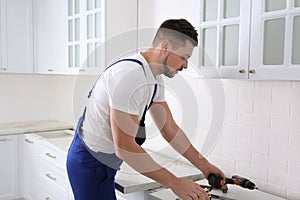 Worker installing furniture in renovated kitchen