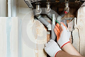 A worker is installing the gas boiler pipes