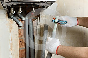 A worker is installing the gas boiler pipes