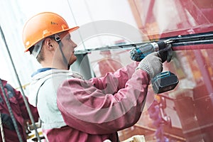 Worker installing glass window on building