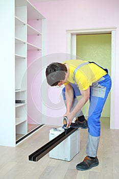 Worker installing guide rails for sliding wardrobe photo