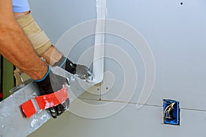 Worker installing gypsum board to wall