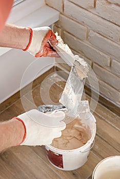 A worker is installing brick tiles on the wall
