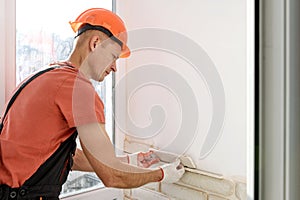 The worker is installing brick tiles on the wall