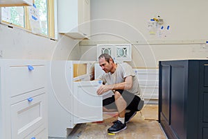worker installing kitchen cupboard photo
