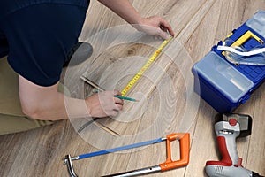 Worker installing laminate flooring. Renovation of home concept.