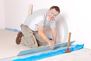 Worker installing a laminated flooring