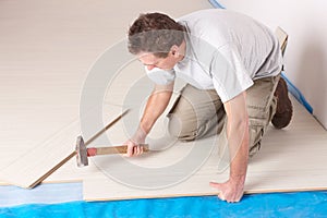 Worker installing a laminated flooring