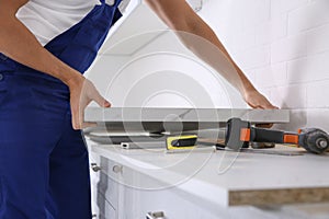 Worker installing new countertop in kitchen