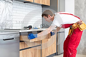 Worker installing new countertop in modern kitchen