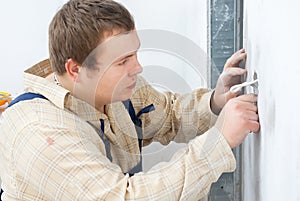 Worker installing power socket in wall
