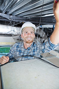 Worker installing smoke detector in ceiling