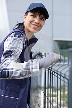 worker installing welded metal mesh fence