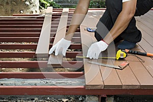 Worker installing wood floor for patio