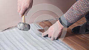 Worker installing wood laminate on the floor